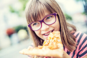 Girl eating pizza with braces